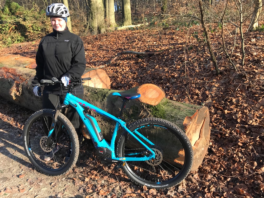 Lucky Bike Mitarbeiterin mit dem Cube Access Hybrid Race 500 E-Mountainbike im Wald.