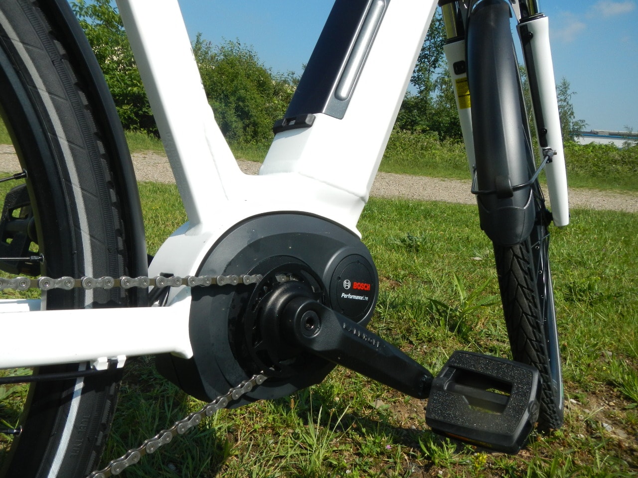 Weißes Kalkhoff E-Bike mit Tiefeinstieg, Gepäckträger und Federgabel in Seitenansicht.