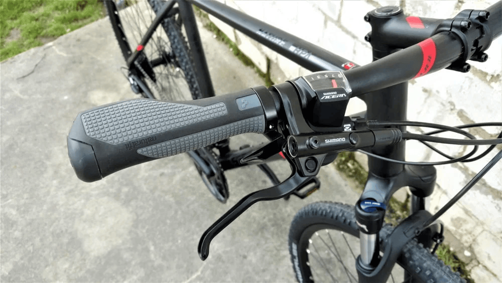 Nahaufnahme des Shimano Acera Schalthebels am Fahrradlenker des Cube Nature Pro Mountainbikes.