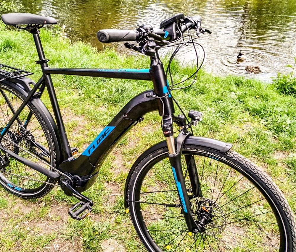 Cube Kathmandu Hybrid EXC 500 E-Trekkingbike auf einer Wiese.