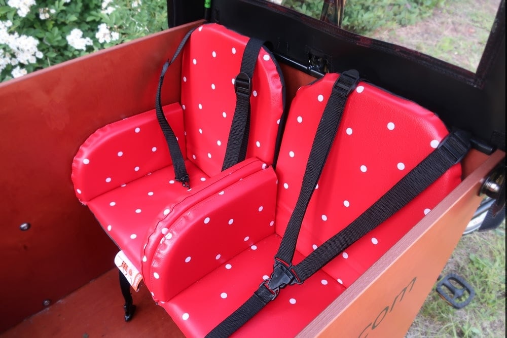 Nahaufnahme der Kindersitze mit Gurten in der Transportbox eines Babboe Big-E Lastenrads.