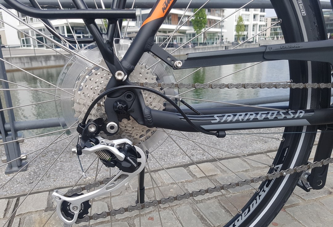 Nahaufnahme der Shimano Deore XT Schaltung mit Kettenschutz am KTM Saragossa Trekkingrad.