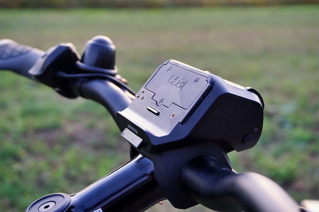 Nahaufnahme einer Smartphone-Halterung von COBI am Lenker eines E-Bikes.