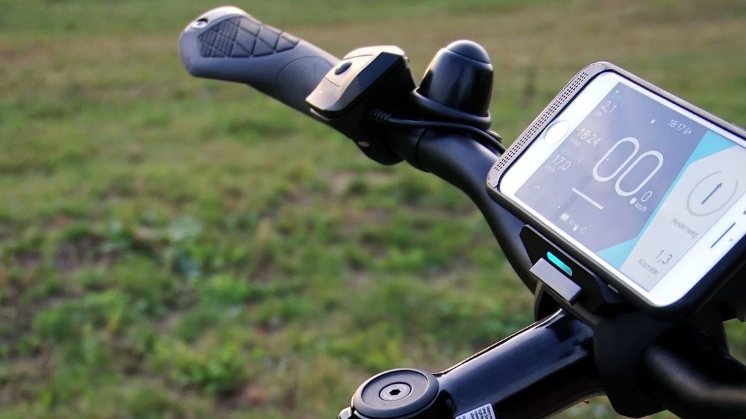 Nahaufnahme eines Smartphones als Display am Lenker eines E-Bikes.