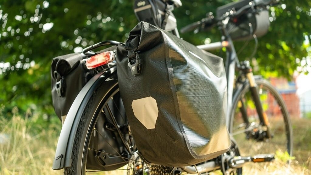 Schwarze Fahrradtasche auf dem Gepäckträger eines Fahrrads.