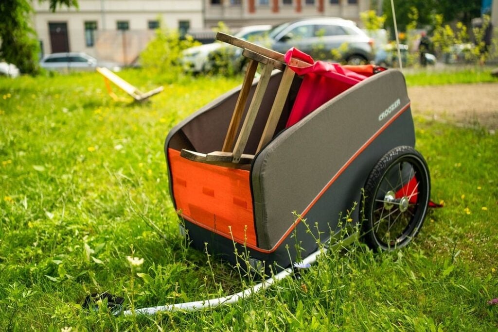 Fahrrad mit Croozer Kinderanhänger auf einem Weg im Grünen.