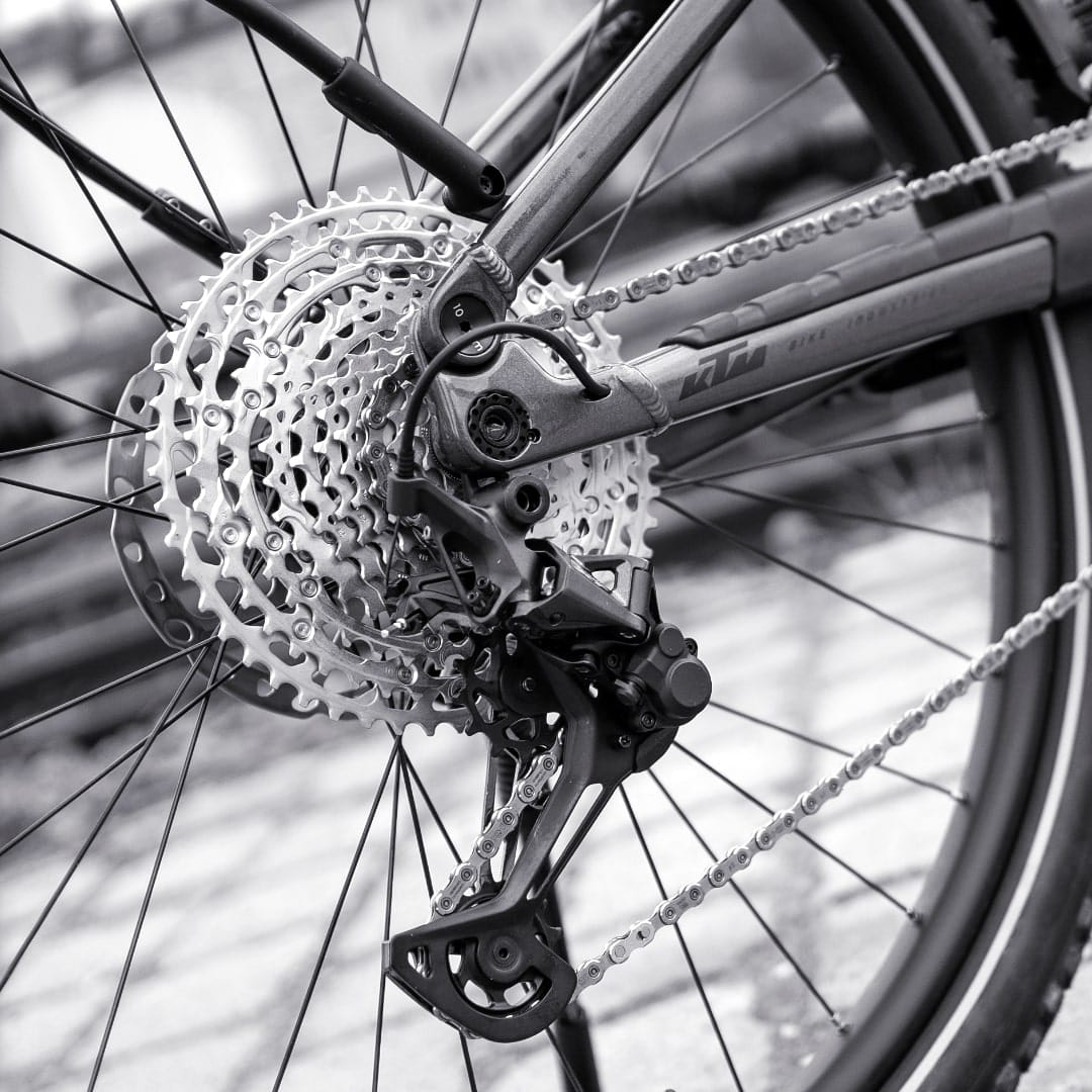 Nahaufnahme einer Fahrrad-Kettenschaltung mit Kassette, Kette und Schaltwerk am Hinterrad.