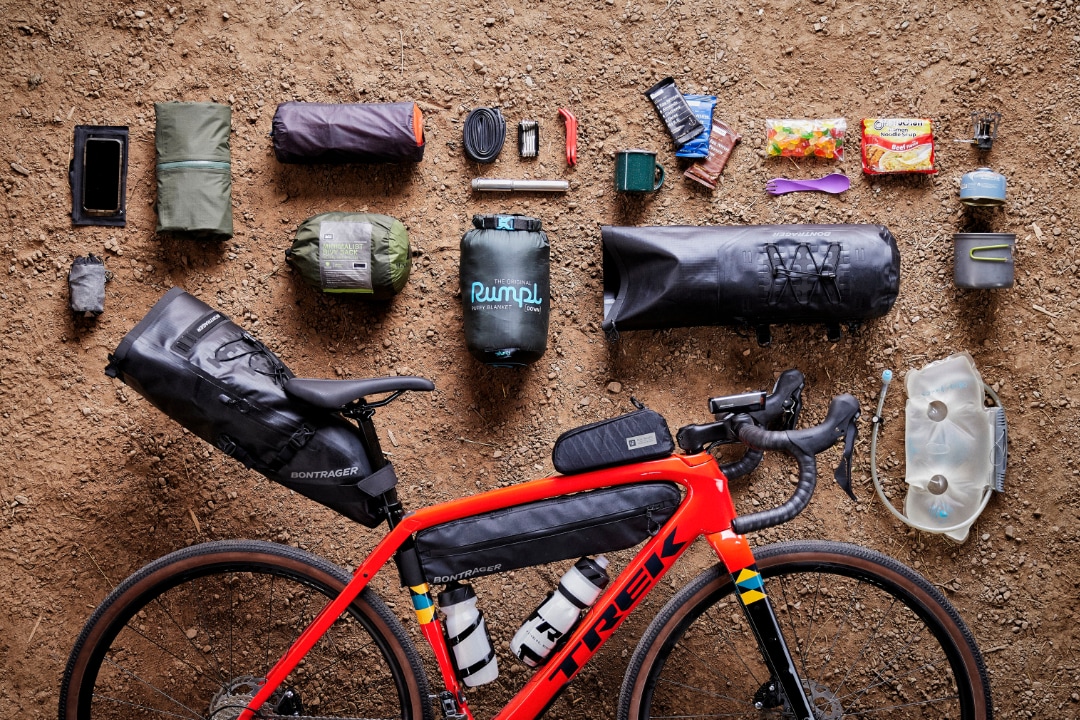 Trek Checkpoint SLR Gravelbike mit Bikepacking-Taschen und ausgebreiteter Tourenausrüstung.