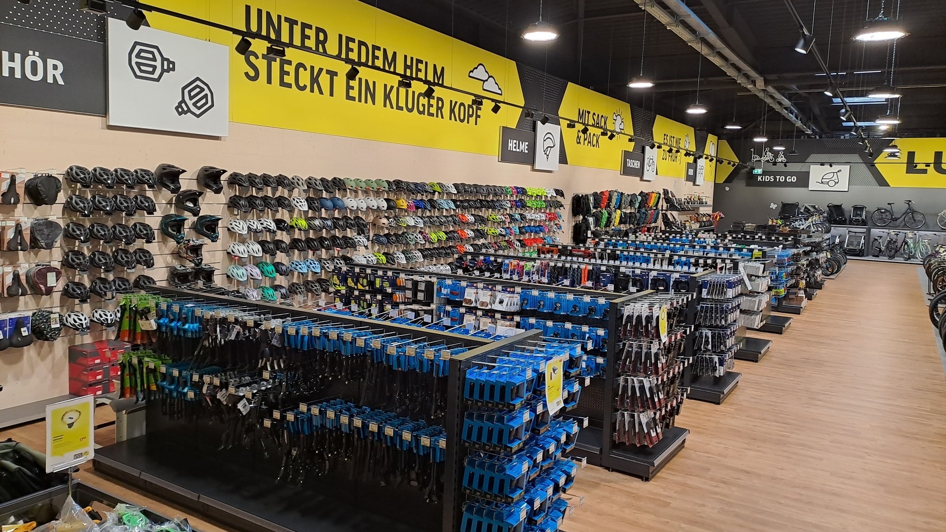 Innenansicht einer Lucky Bike Filiale mit Fahrradhelmen und Fahrradzubehör in den Verkaufsregalen.