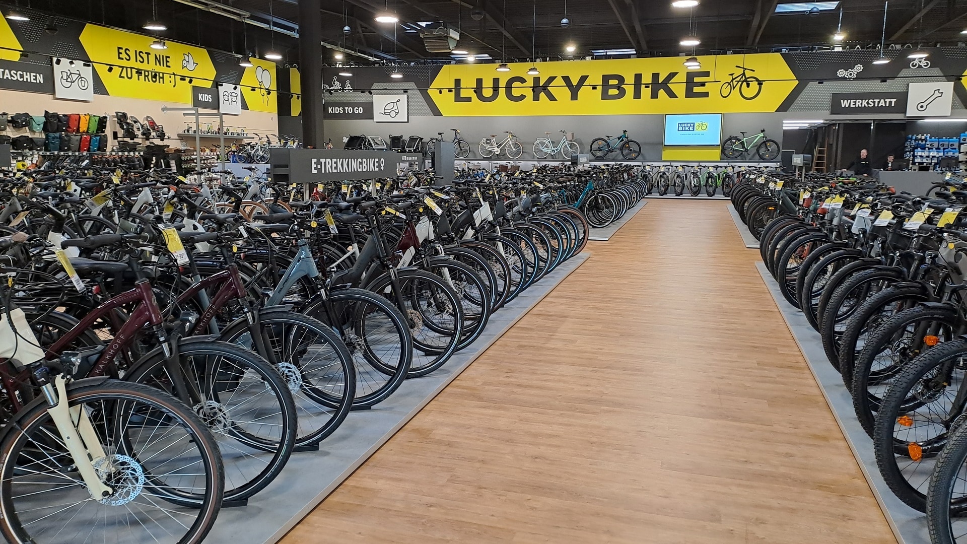 Innenansicht der Lucky Bike Filiale in Hildesheim mit großem gelben Lucky Bike Schriftzug und Fahrräderreihen.