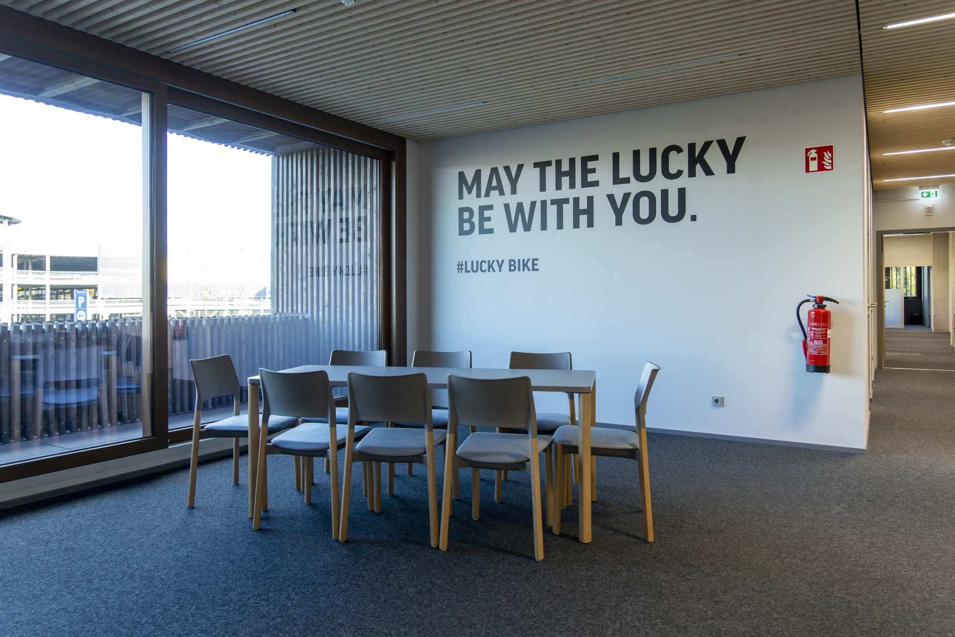 Konferenzraum mit weißer Wand mit der Schrift: "May the Lucky be with you."