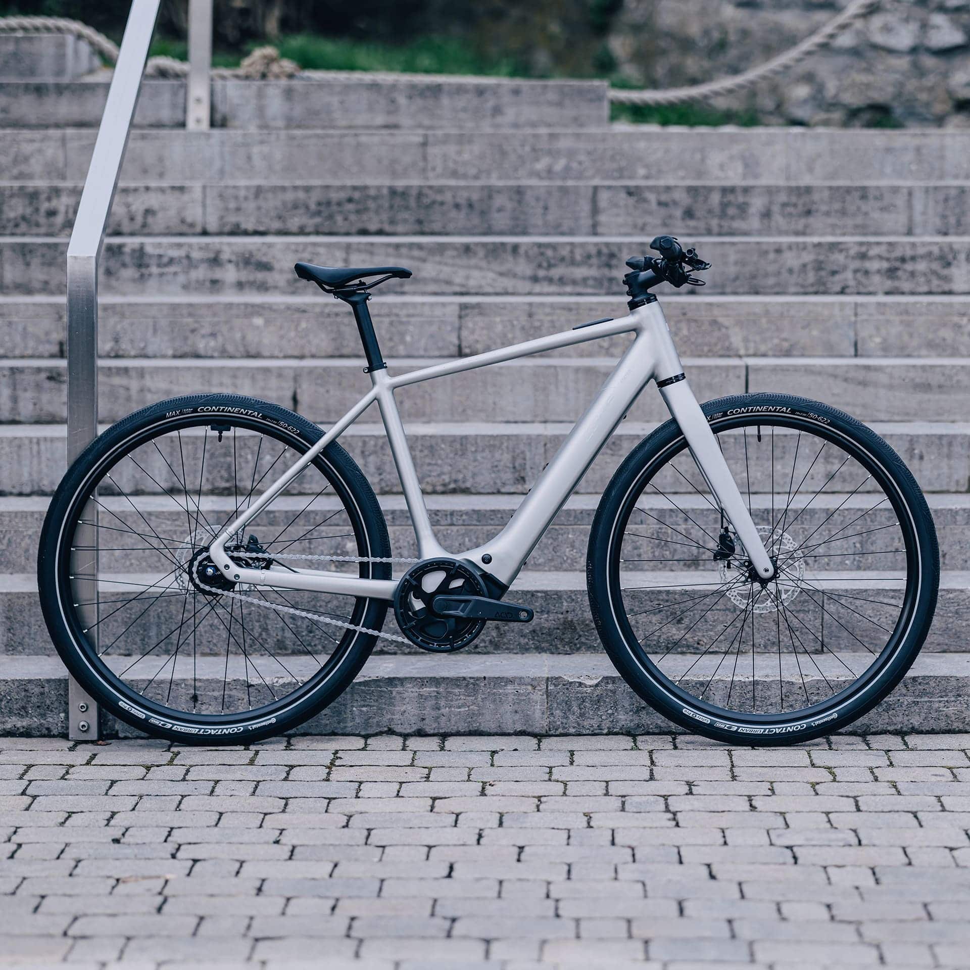 Cube Editor Hybrid E-Bike in Seitenansicht vor urbaner Kulisse.