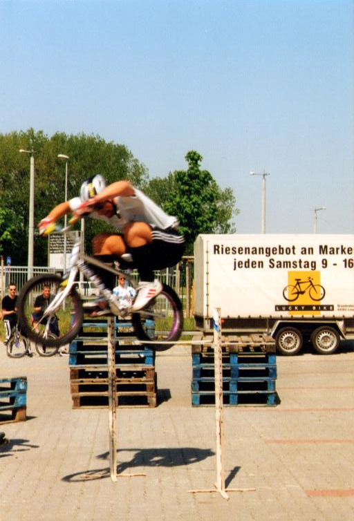 Mountainbiker springt mit seinem Fahrrad über ein Hindernis aus Paletten.