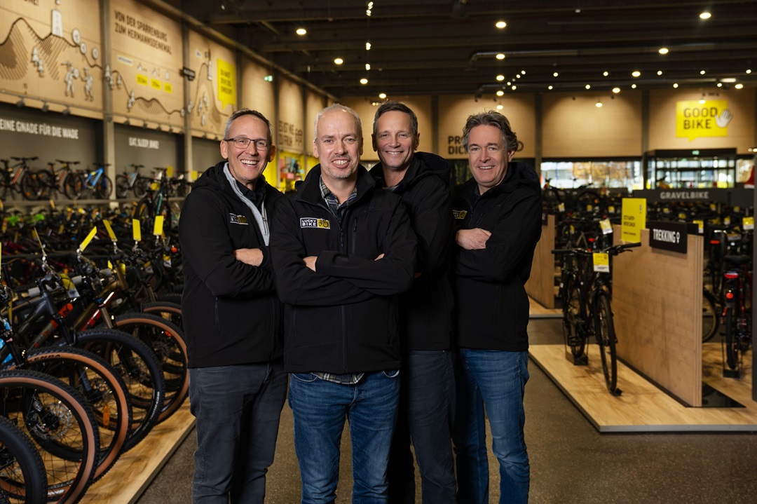 Die vier Lucky Bike Geschäftsführer stehen gemeinsam in einer Lucky Bike Filiale vor Fahrrädern und Verkaufsflächen.