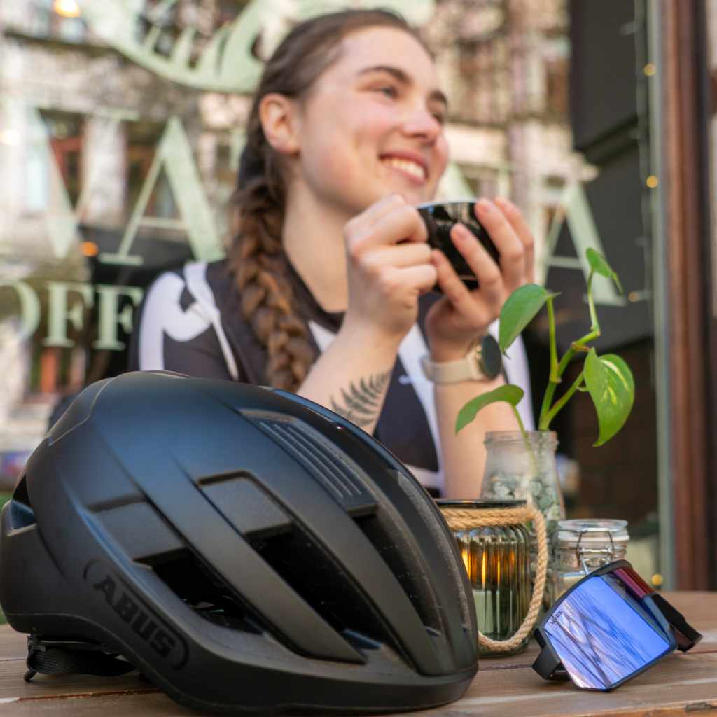 Mädchen sitzt am Tisch mit Abus Fahrradhelm und Fahrradbrille