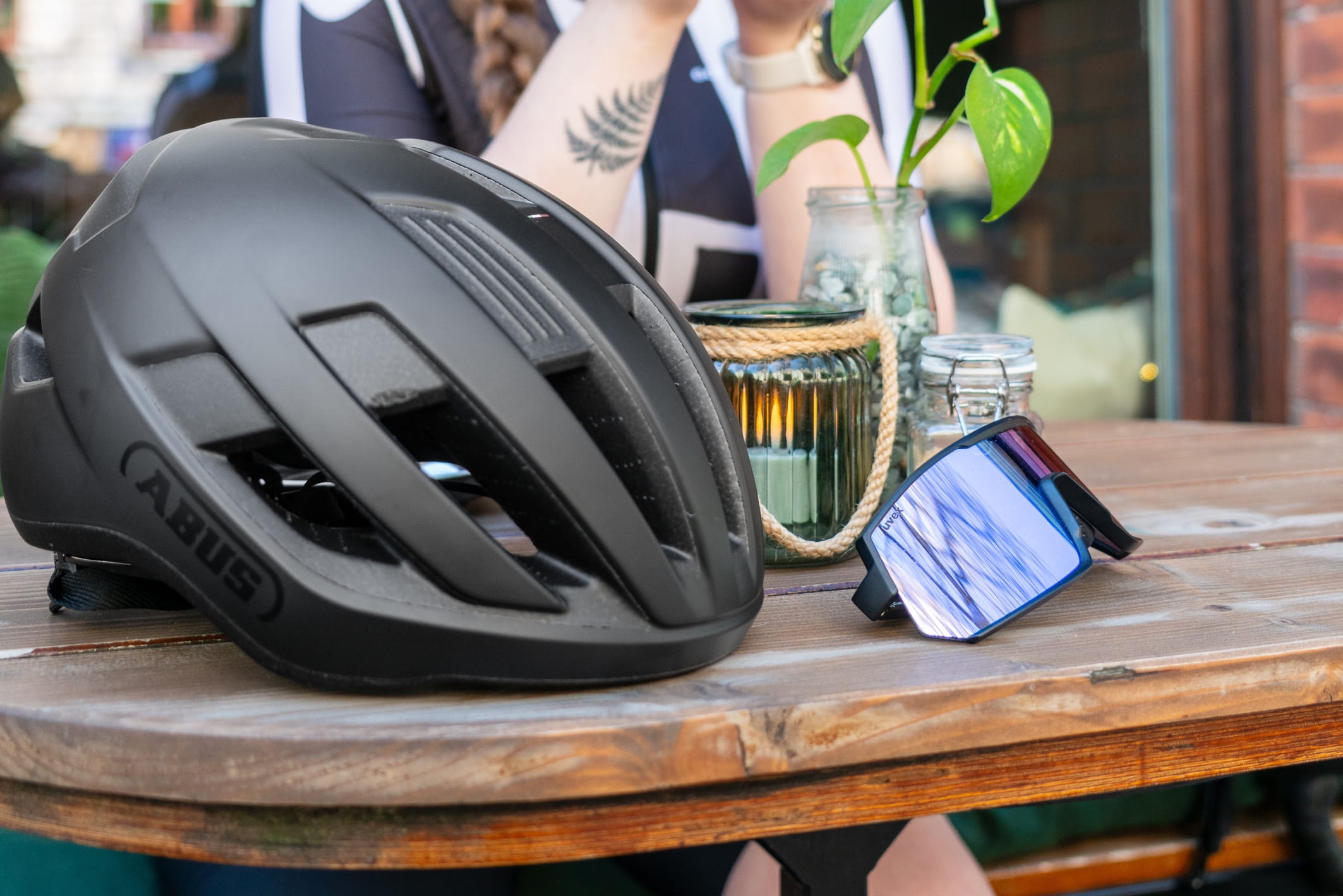 Auf einem Gartentisch liegen Fahrradhelm und eine Fahrradbrille