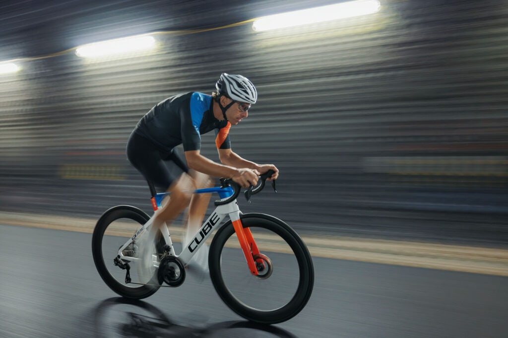 Seitenansicht einer Person, die auf einem Rennrad in urbaner Gegend fährt