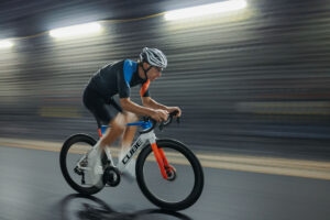 Seitenansicht einer Person, die auf einem Rennrad in urbaner Gegend fährt