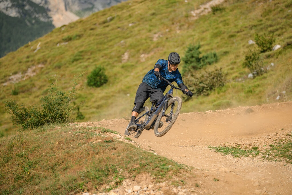 Dynamisches Bild einer Person, die auf einem CUbe Mountainbike in ländlicher Umgebung fährt