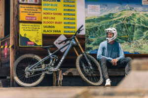Ein Mann sitzt auf einer Bank und sein Mountainbike von Cube steht daneben. SIeht nach einer Rast aus.