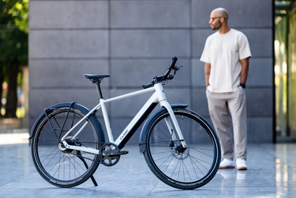 Urbanes E-bike mit einer Person stehend daneben in urbaner Kulisse