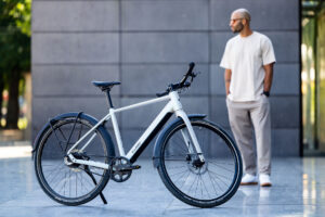 Urbanes E-bike mit einer Person stehend daneben in urbaner Kulisse