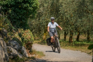 Eine Person fährt mit einem E-Bike auf losem Untergrund um eine Kurve