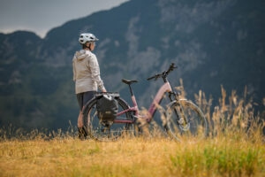 Perspektive von hitnen auf eine Person, die neben einem E-Bike von Cube steht in ländlicher Umgebung